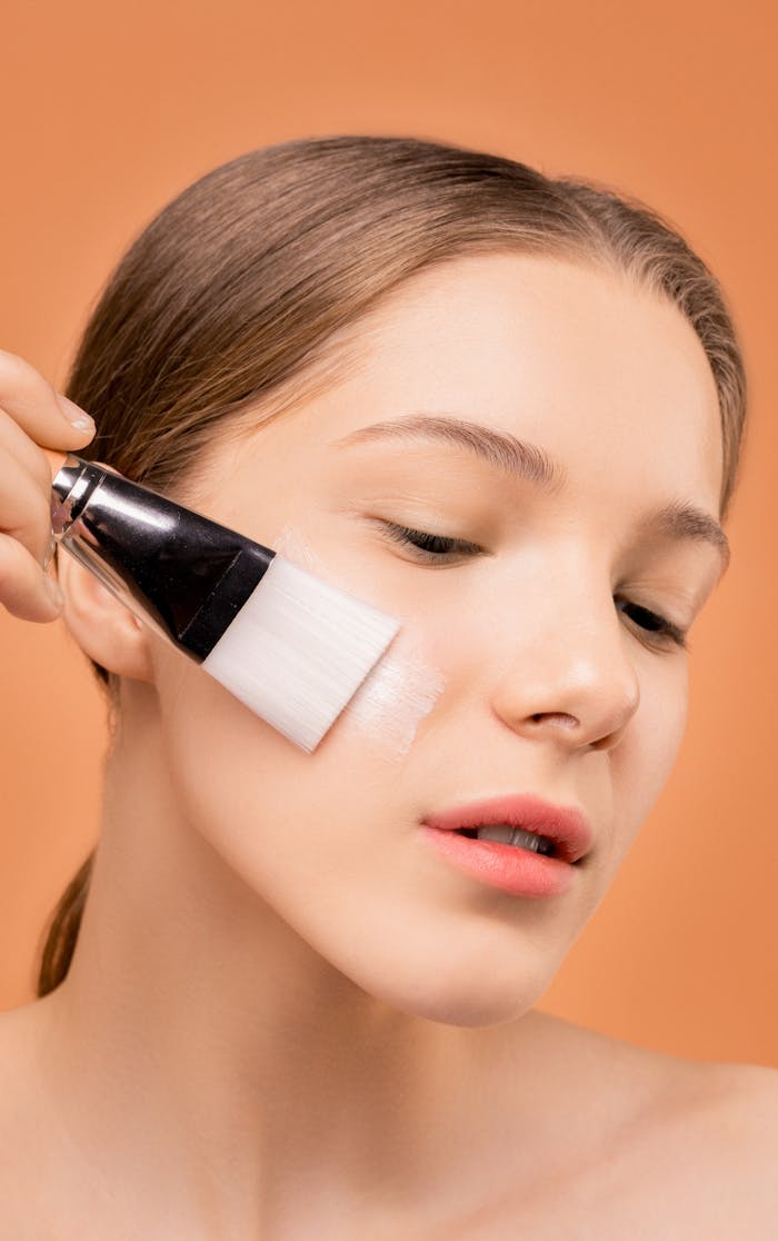 Woman Applying Moisturizer on Her Face Using Brush